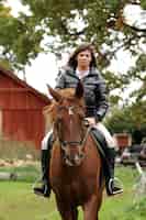 Bezpłatne zdjęcie kobieta i jej brązowy koń