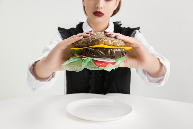 Kobieta je burger z tworzywa sztucznego, koncepcja eko.