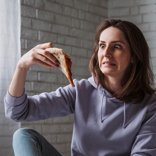 Bezpłatne zdjęcie kobieta jedzenie pizzy w domu
