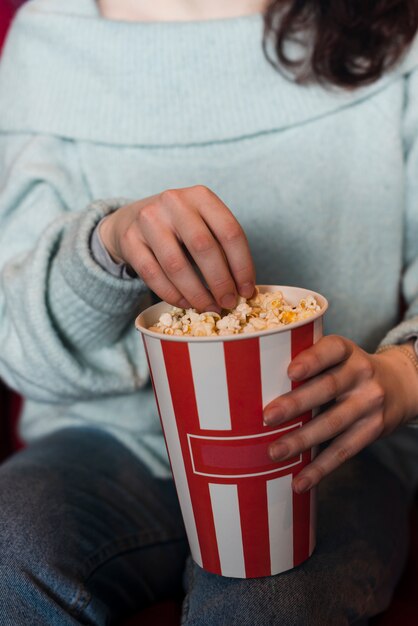 Kobieta jedzenie popcornu w kinie