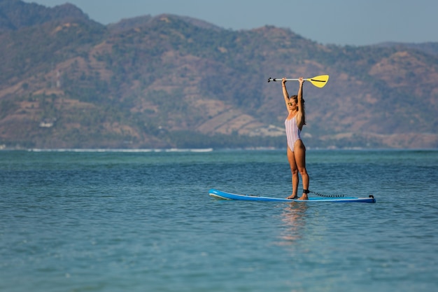 Bezpłatne zdjęcie kobieta jedzie sup. . bali. indonezja