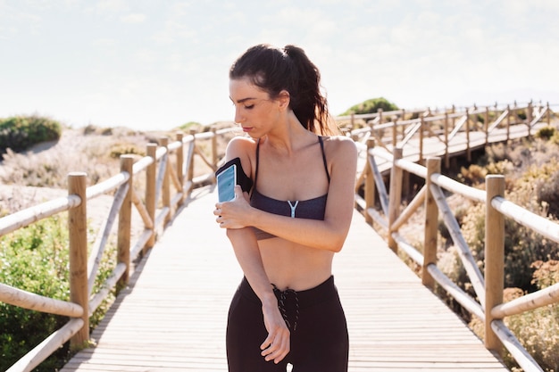 Kobieta jogger przymocowanie smartphone na ramieniu