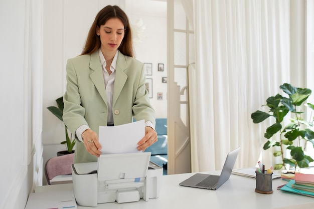 Kobieta korzystająca z drukarki biurowej w widoku z przodu