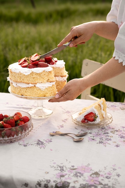 Bezpłatne zdjęcie kobieta krojąca tort o wysokim kącie