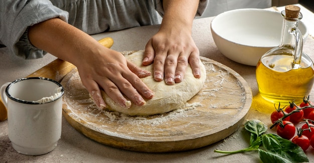 Kobieta kucharz przygotowuje ciasto do pizzy