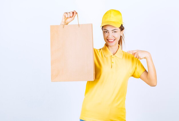 Kobieta kurier trzyma kartonową torbę na zakupy i uczucie szczęścia.