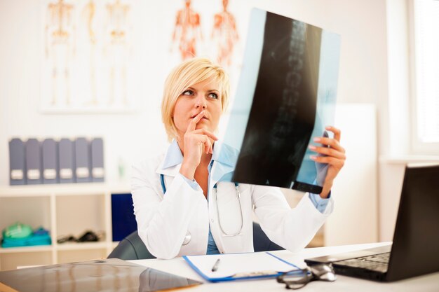 Kobieta lekarz studiuje prześwietlenie kręgosłupa