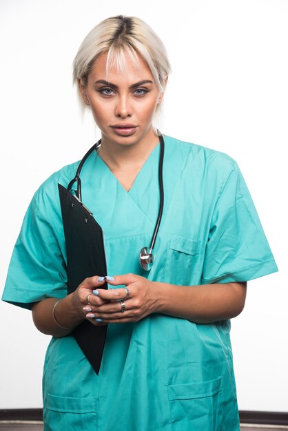 Kobieta lekarz trzymając schowek na białej powierzchni