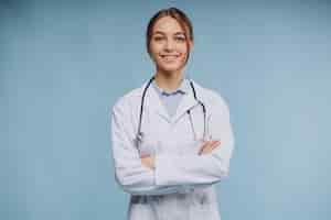 Bezpłatne zdjęcie kobieta lekarz ubrany w fartuch laboratoryjny ze stetoskopem na białym tle