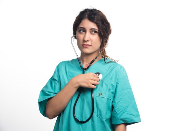 Kobieta lekarz za pomocą stetoskopu na białym tle. Wysokiej jakości zdjęcie