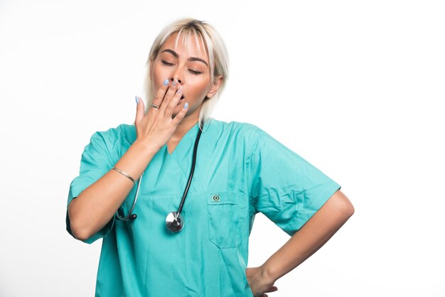 Kobieta lekarz ze stetoskopem senny na białym tle. Wysokiej jakości zdjęcie