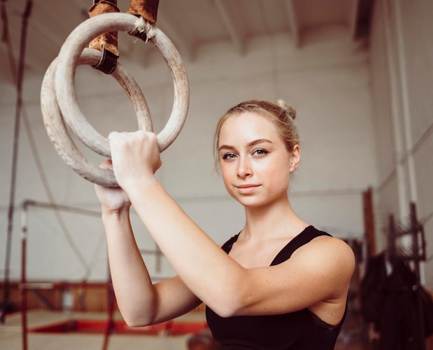 Bezpłatne zdjęcie kobieta lekkoatletycznego szkolenia na pierścieniach gimnastycznych