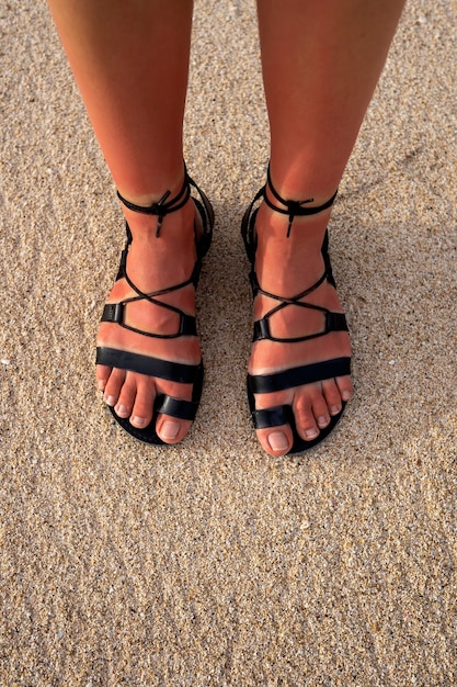 Kobieta ma na sobie rzymskie sandały na plaży