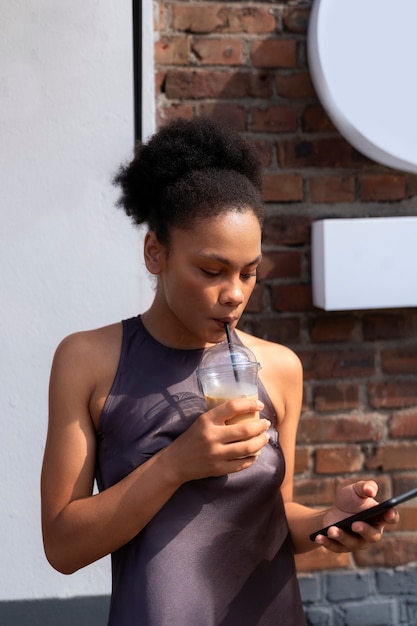 Bezpłatne zdjęcie kobieta ma przerwę na mrożoną kawę na zewnątrz