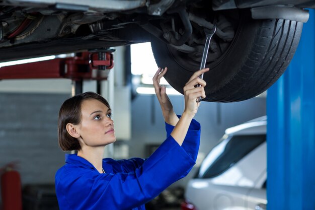 Kobieta mechanik mocowania hamulca tarczowego koła samochodu