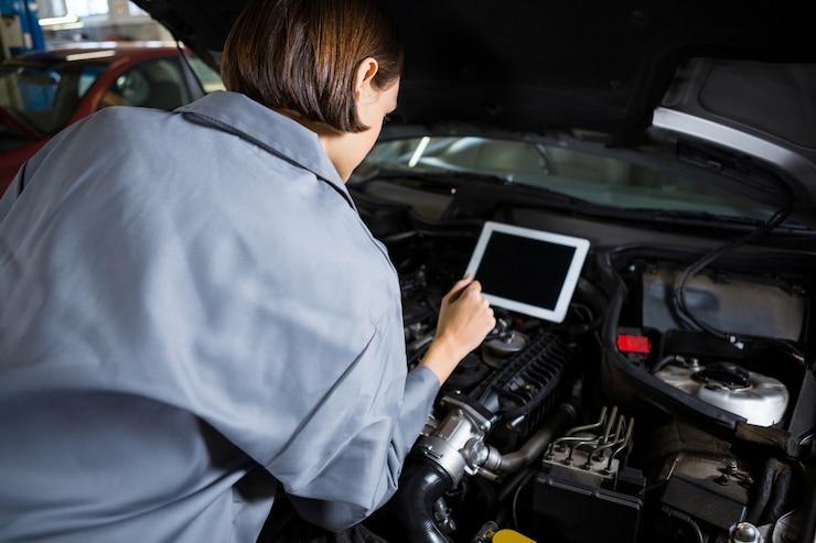 Bezpłatny plik Zdjęcie kobieta mechanik przy pomocy przyrządu diagnostycznego