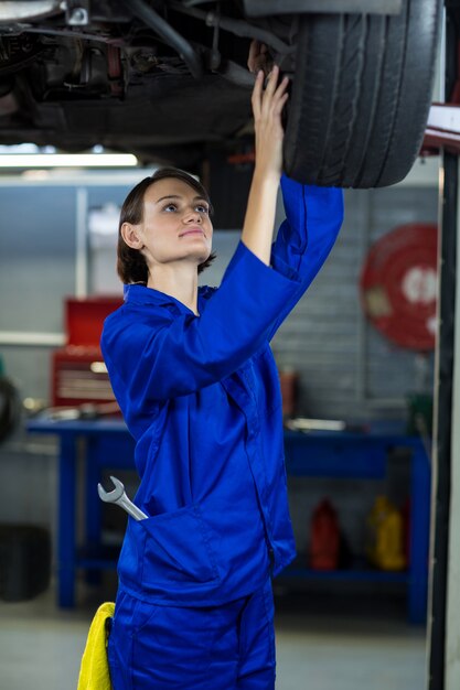 Kobieta mechanik samochodowy sprawdzenie hamulca tarczowego koła