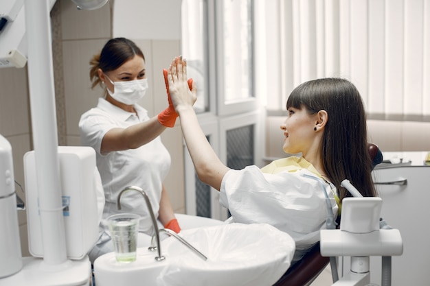 Kobieta Na Fotelu Dentystycznym. Dziewczynka Jest Badana Przez Dentystę, Lekarz Podaje Pięciu Pacjentom