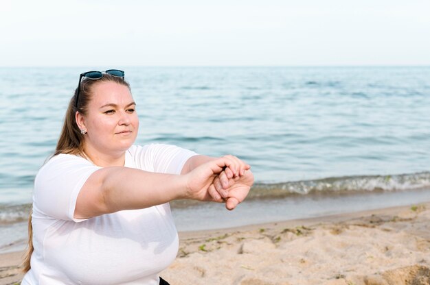 Kobieta na plaży robi ćwiczenia sportowe