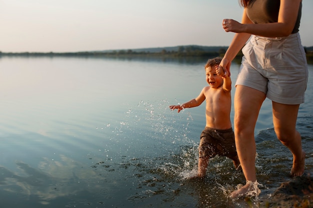 Kobieta na plaży z dzieckiem ciesząca się zachodem słońca