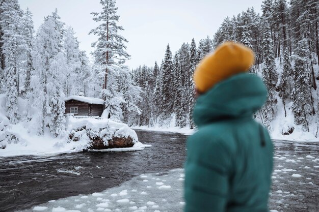 Kobieta nad zamarzniętą rzeką w Laponii, Finlandia