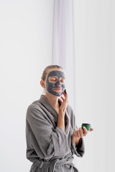 Kobieta nakładająca maskę w łazience