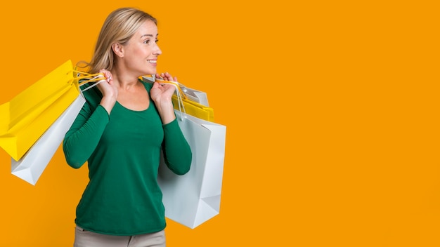 Bezpłatne zdjęcie kobieta niosąca wiele toreb na zakupy po szaleństwie zakupów