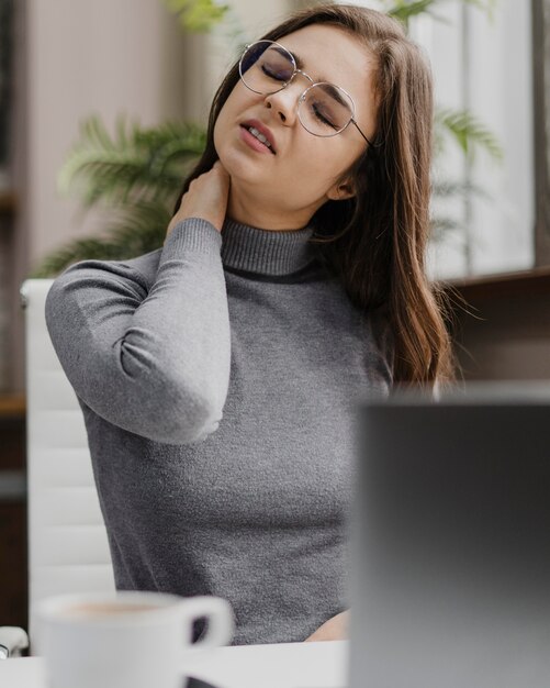 Kobieta o bólu szyi podczas pracy w domu