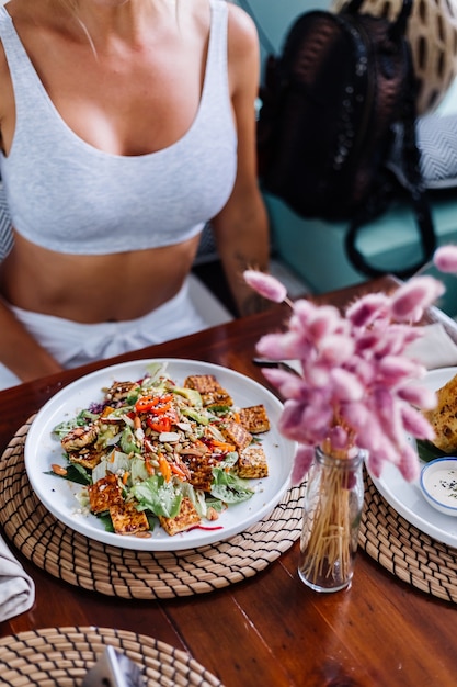 Kobieta o kolorowe zdrowe wegańskie wegetariańskie posiłek sałatka w letniej kawiarni naturalnym świetle dnia