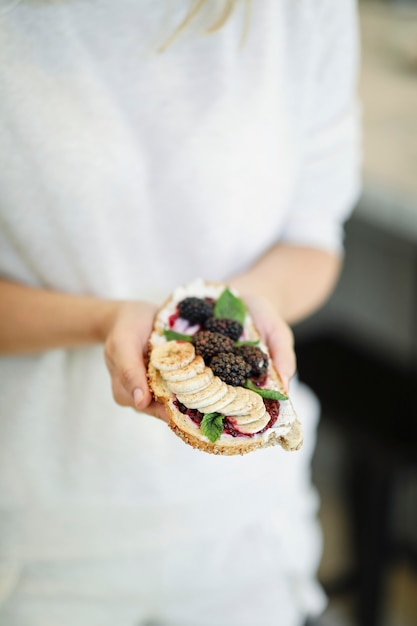 Kobieta o toast z dżemem jeżynowym i wegańskie serek śmietankowy