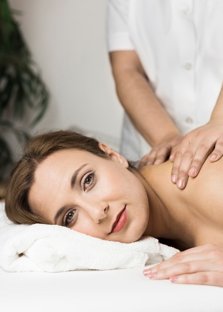 Bezpłatne zdjęcie kobieta odbiera masaż w centrum spa