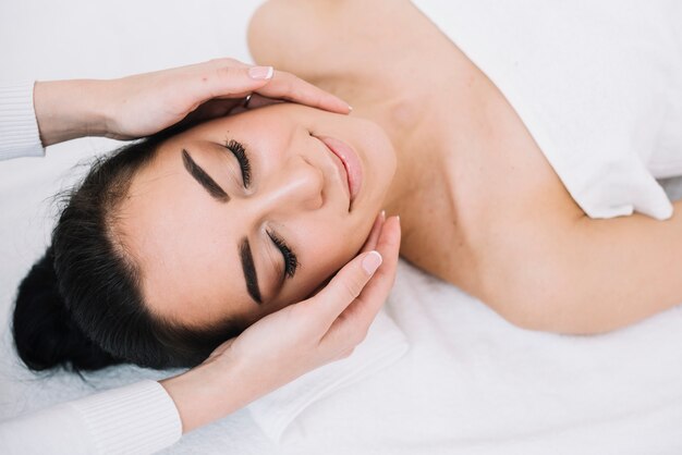 Kobieta odbiera relaksujący masaż twarzy