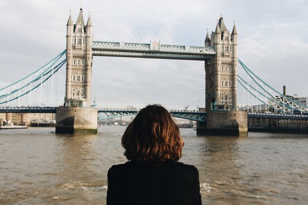 Kobieta patrząca na słynny Tower Bridge St UK podczas dziennego Tower Bridge w Wielkiej Brytanii