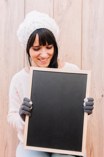 Bezpłatne zdjęcie kobieta patrzeje chalkboard w pulowerze