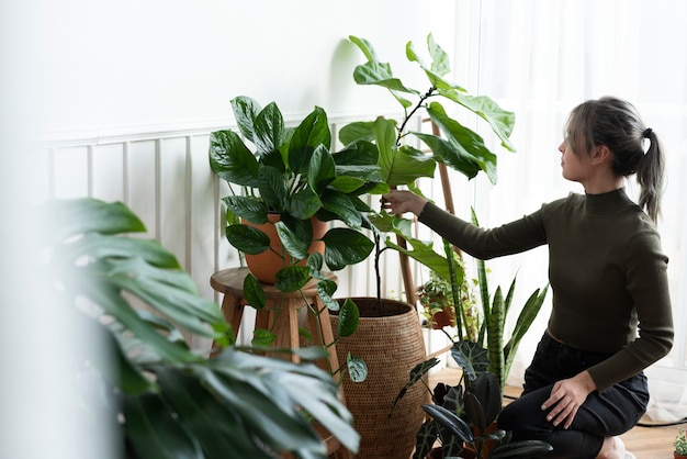 Bezpłatne zdjęcie kobieta pielęgnująca i opiekująca się swoją rośliną