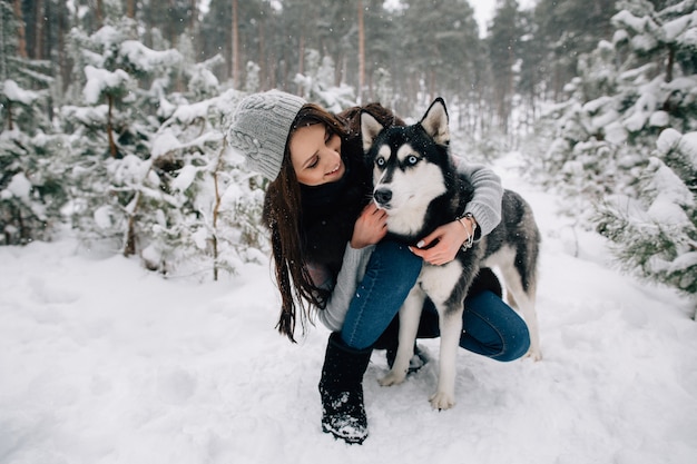 Kobieta pieści psa Husky w zimie śnieżny zimny dzień