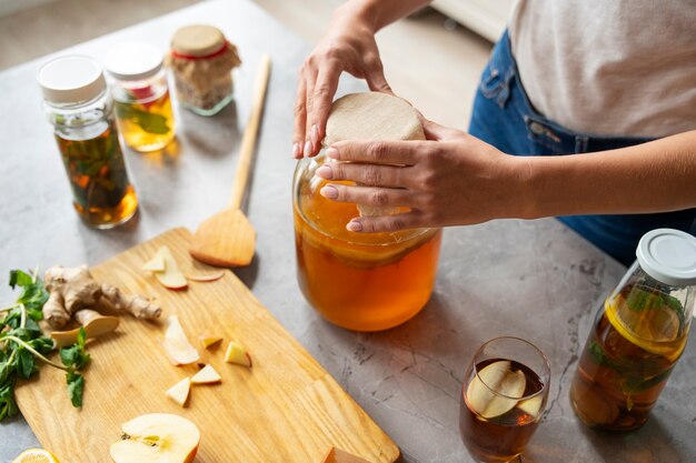 Kobieta pod dużym kątem przygotowująca kombucha