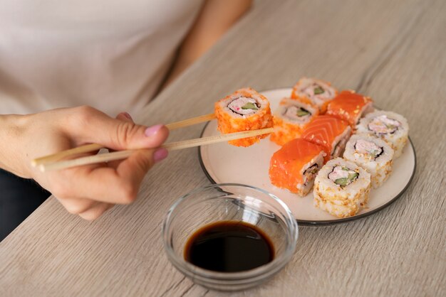 Kobieta pod dużym kątem z pysznym sushi w domu