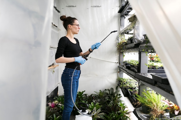 Kobieta podlewania roślin w cieplarni