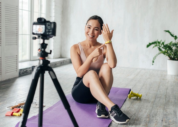 Bezpłatne zdjęcie kobieta pokazująca trening fitness na nowy vlog