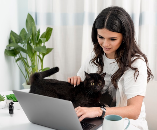 Kobieta pracuje jako freelancer i bawi się z kotem