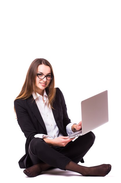 Kobieta pracuje na laptopie na białym tle na białej ścianie