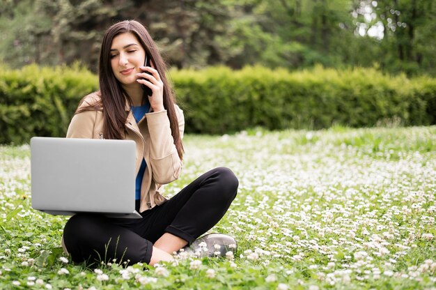 Kobieta pracuje na laptopie w naturze