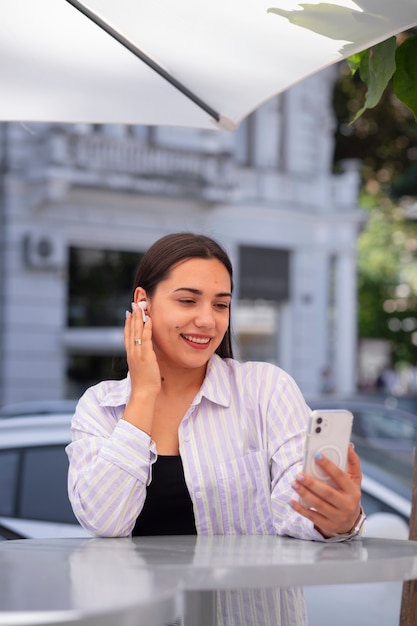 Bezpłatne zdjęcie kobieta prowadząca rozmowę wideo na smartfonie podczas pobytu w mieście