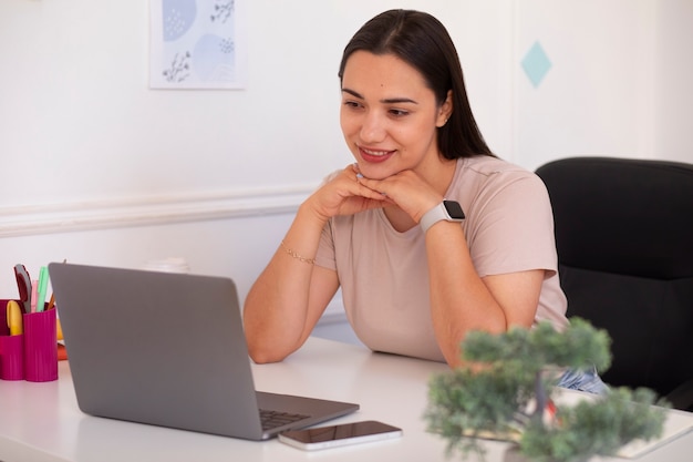 Bezpłatne zdjęcie kobieta prowadząca rozmowę wideo przy użyciu laptopa w domu