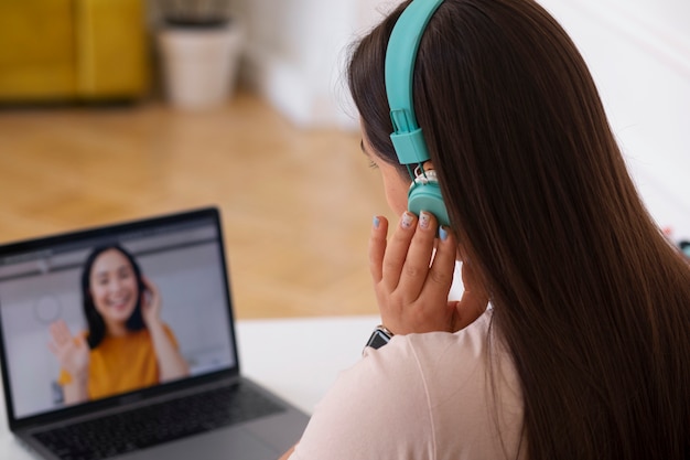 Bezpłatne zdjęcie kobieta prowadząca rozmowę wideo przy użyciu laptopa w domu