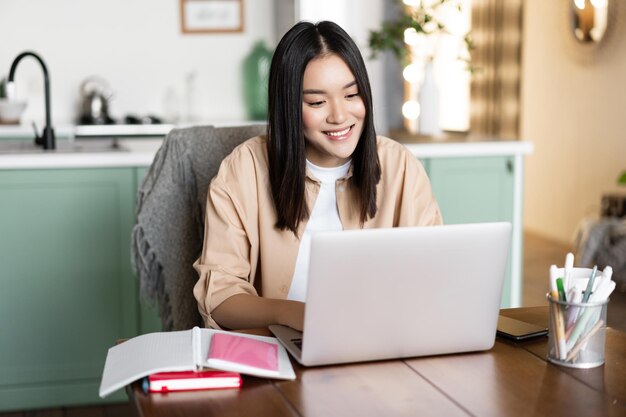 Kobieta prowadząca wideoczat online w szkole na komputerze uśmiechająca się do laptopa kamera dziewczyna ucząca się zdalnie fr...