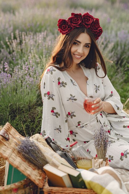 Kobieta Prowansji relaks w lawendowym polu. Pani na pikniku. Kobieta w wieńcu kwiatów.