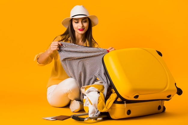 Bezpłatne zdjęcie kobieta przechodzi przez jej bagażu wakacje