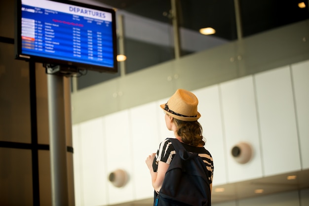 Bezpłatne zdjęcie kobieta przed panelem informacji o lotnisku
